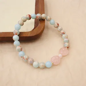 Detail view showing the elegant texture of handmade natural stone bracelet with rose quartz hearts