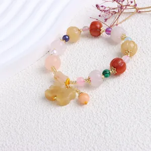 Makroansicht des Goldsilk-Jade-Armbands mit geschnitzten Kürbisperlen und Jadeanhänger
