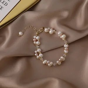 Elegantes Süßwasserperlen-Armband mit Kristallakzenten auf champagnerfarbenem Satin
