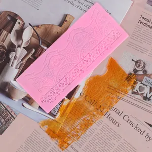 Detailed view of pink silicone fondant lace mold and amber-colored edible lace mat