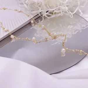 Close-up of elegant Y-shaped tassel necklace with natural pearls and gold beads