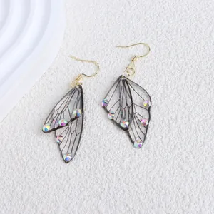 Macro view of translucent cicada wing earrings with sparkling iridescent rhinestones