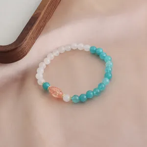 Nahaufnahme eines Naturkristallarmbands mit grünen Achatperlen und einer orangefarbenen Akzentperle