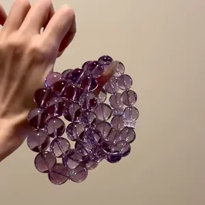 Close-up of three 12mm natural amethyst bead bracelets with translucent purple texture