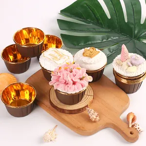 Caissettes à cupcakes dorées sur planche en bois avec muffins décoratifs pour la pâtisserie.