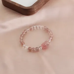 Close-up of natural strawberry quartz crystal bracelet with carved centerpiece.