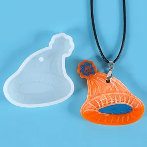 Detailed view of hat-shaped silicone mold and finished orange resin pendant on black cord.
