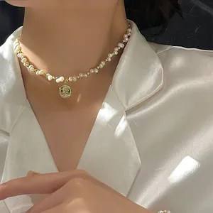 Detail einer handgefertigten Süßwasserperlenkette mit Goldmünzen-Anhänger.