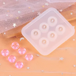 Detail van siliconen mal voor DIY hars kralen en roze gefacetteerde sieraden.