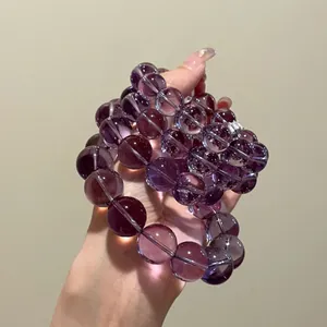 Macro detail of 12mm natural purple amethyst crystal beads showing high transparency