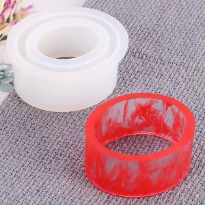 Detailed view of a silicone mold for DIY resin jewelry with a finished red bangle.