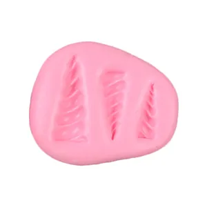 Macro view of a pink silicone mold with three sizes of spiraled unicorn horn cavities for crafts.