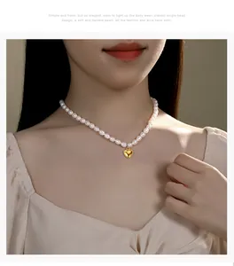 Nahaufnahme einer eleganten Süßwasserperlenkette mit einem goldenen Herzanhänger