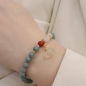 Dettaglio ravvicinato di bracciale in giadeite con quarzo fragola e ciondolo hulu