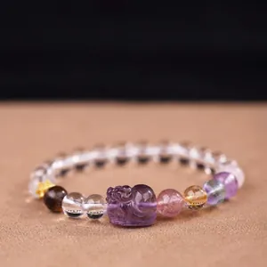 Close-up detail of amethyst multi-gemstone bracelet with Pixiu carving on dark background