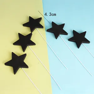 Primer plano de cinco adornos para pasteles en forma de estrella de espuma negra fiesta