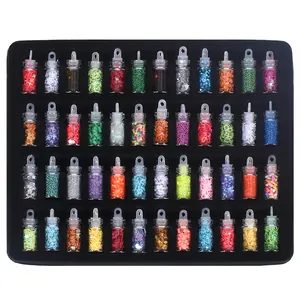 Collection of colorful decorative glitters and sequins in small clear bottles for DIY