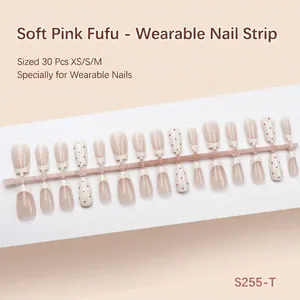 Macrodetail van 30 handgemaakte kunstnagels met Franse tips en rode stippenpatronen