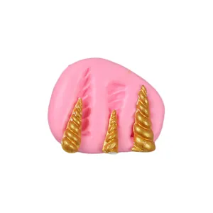 Detailed view of pink silicone mold with three spiral unicorn horn shapes for DIY.