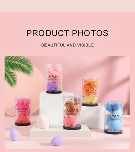 Professional set of multicolored makeup sponges in clear canisters on a pink background