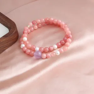 Macro view of a double-layered pink crystal beaded bracelet with elegant pearls
