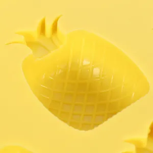 Close-up detail view of a pineapple shaped yellow silicone ice cube mold with grid texture