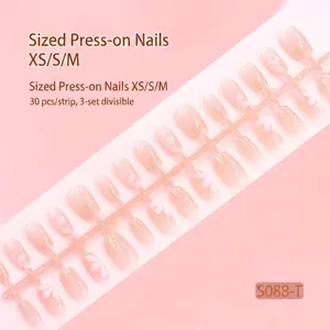 Detailed view of nude press-on nail strip with subtle glitter finish and floral art