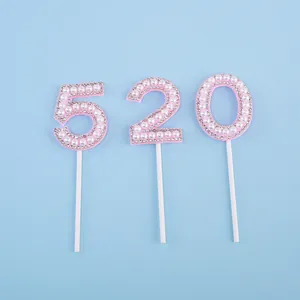 Decoración de tarta rosa número 520 con perlas y diamantes en fondo azul claro