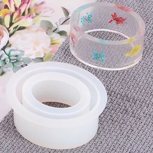 Close-up of silicone mold and finished resin bangle with colorful dried flowers