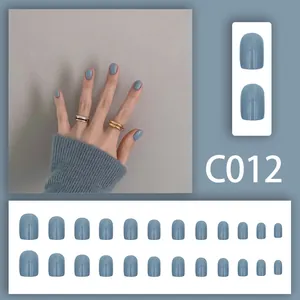 Detailed view of 24pcs short solid blue-grey press-on nails with model hand display