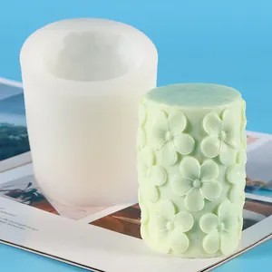 Détail du moule en silicone cylindrique et bougie verte à motifs floraux