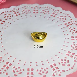 Macro-opname van een 2,2 cm kleine gouden plastic Chinese Yuanbao-staaf voor taartdecor