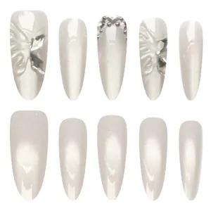 Elegant pearlescent white cat-eye press-on nails featuring 3D butterfly and rhinestone details