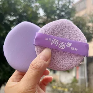 Close-up detail of the dual-sided purple makeup puff showing smooth and porous textures