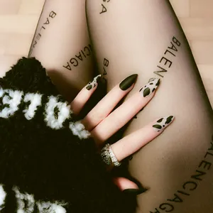 Detailed view of fashionable leopard print and matte dark green long stiletto press-on nails