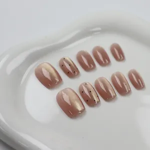 Primer plano detallado de uñas postizas ojo de gato melocotón con diseño de puntos brillantes