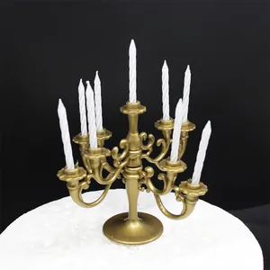 Retro gold nine-arm candelabra cake topper with elegant white spiral candles for parties