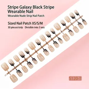 Gros plan de 30 faux ongles nude avec rayures noires et lignes galaxie argentées