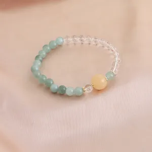 Nahaufnahme eines Naturkristall-Armbands mit grünen Achat- und klaren Quarzperlen.