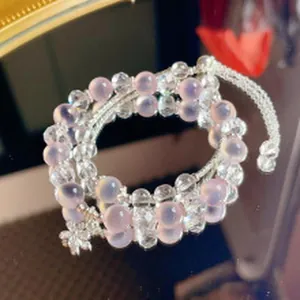 Close-up of elegant layered pink crystal beaded bracelet and necklace with a flower charm.