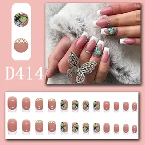 Detailed view of pink French press-on nails with butterfly and rhinestone accents.