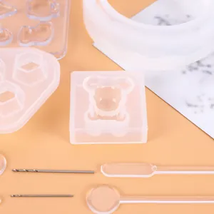 Detailed view of clear bear-shaped silicone resin mold and DIY jewelry craft tools