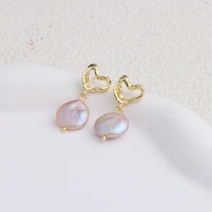 Primo piano che mostra il lustro rosa iridescente delle perle barocche su questi orecchini