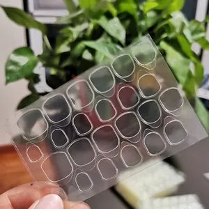 Detailed macro view showing a sheet of 24 transparent double-sided adhesive jelly glue tabs for nails
