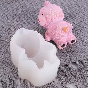 Détail du moule en silicone d'ours 3D avec un ours en mousse rose sur tissu gris