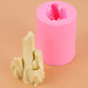 Close-up of pink silicone rockery mold with finished crystal pillar model on plain background.