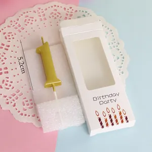 Detailed view of a 5.2cm gold metallic number 1 birthday candle in its white retail box