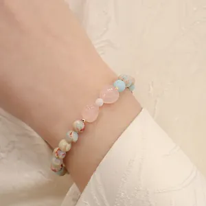 Close-up detail of elegant Shoushan stone and rose quartz beaded bracelet on a wrist