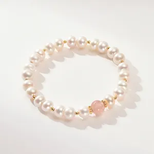 Primer plano de una pulsera de perlas de agua dulce con una cuenta de cuarzo fresa