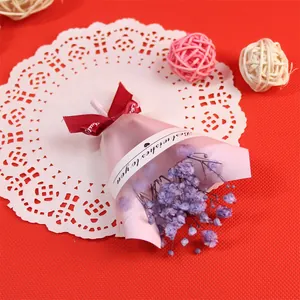 Détail d'un mini bouquet de fleurs de gypsophile séchées violettes pour gâteau